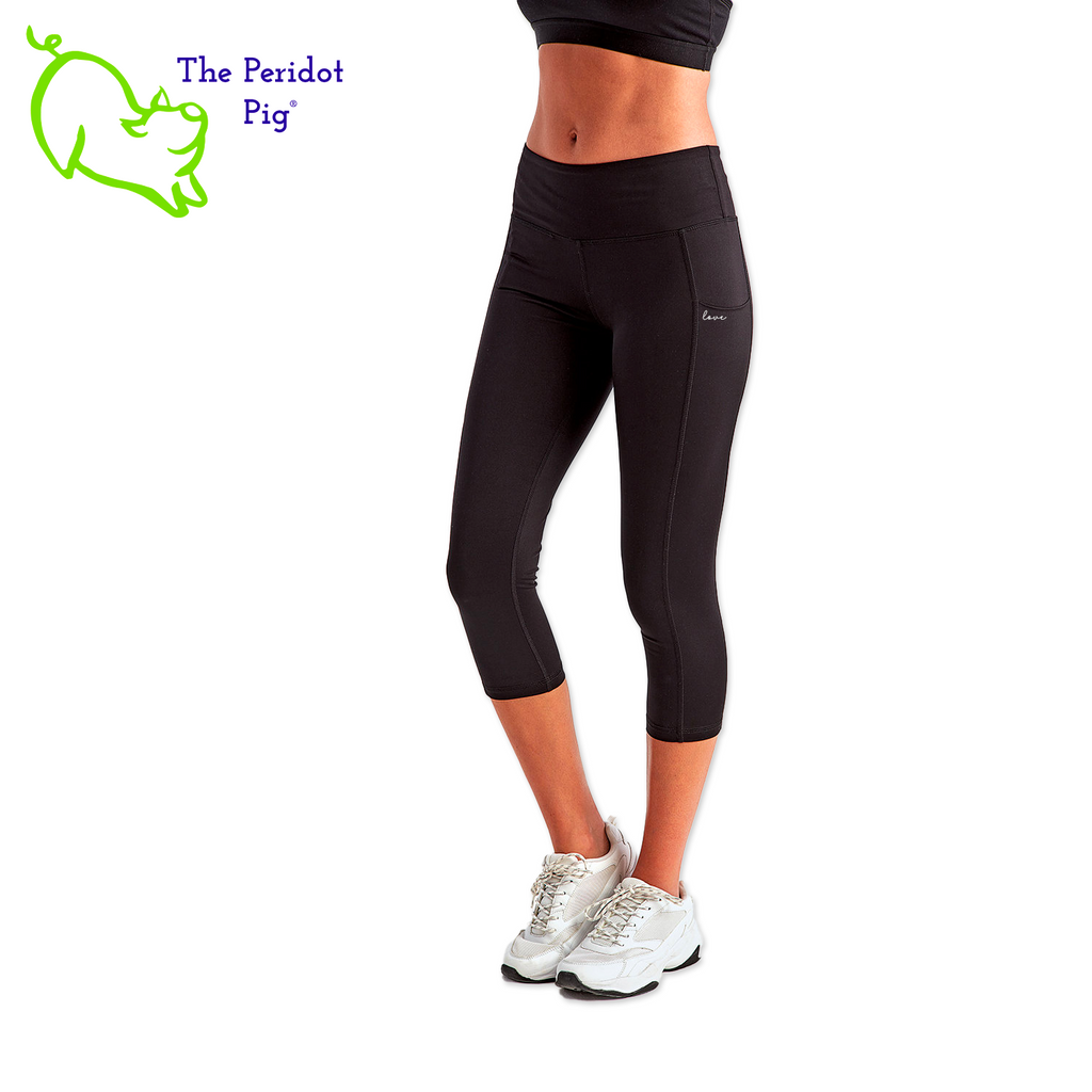 Luxuriate in luxury with the PureBliss Studios Lotus High Rise Capri Legging—super comfortable and breathable with two side pockets, an interior pocket, plus the brand logo on the back right leg in a matte vinyl and a dazzling color lotus on the back. And who wouldn't love a little "love" on the left pocket? Stretchy yet snug-fitting, enjoy the perfect yoga session! Three quarter view shown.