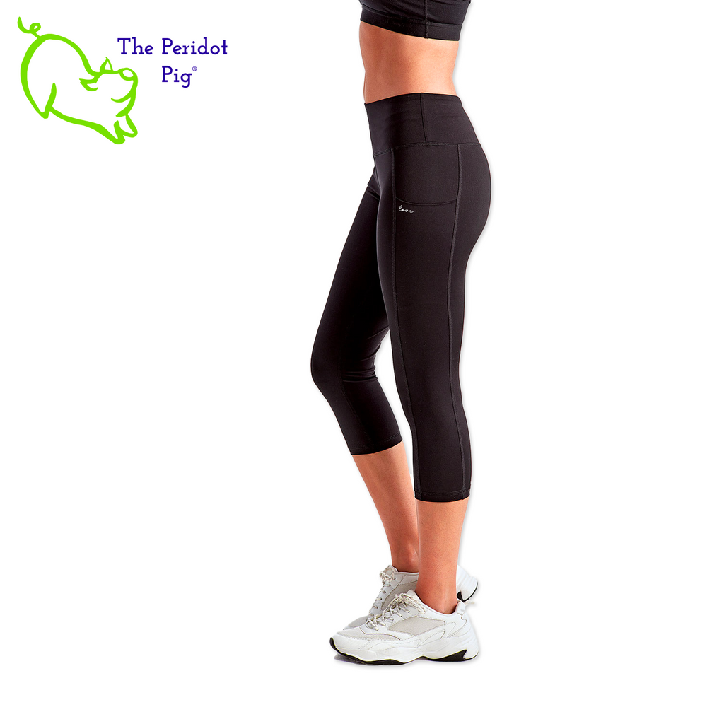 Luxuriate in luxury with the PureBliss Studios Lotus High Rise Capri Legging—super comfortable and breathable with two side pockets, an interior pocket, plus the brand logo on the back right leg in a matte vinyl and a dazzling color lotus on the back. And who wouldn't love a little "love" on the left pocket? Stretchy yet snug-fitting, enjoy the perfect yoga session! Side view shown.