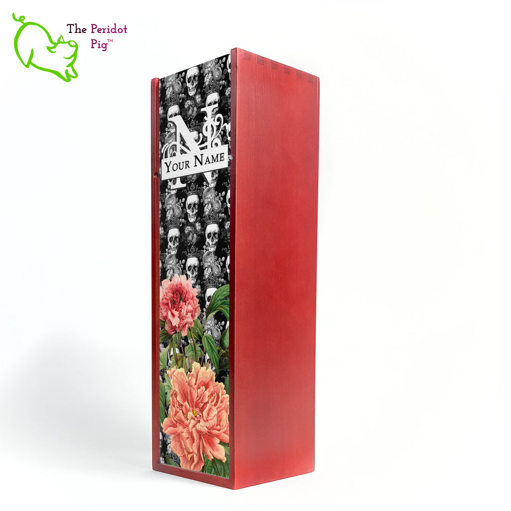 The front panel is decorated in a glossy, detailed print with a monogram and space for a customized name. This model has a background of Victorian skulls wearing a crown. in the foreground, there are two colorful peonies with green foliage. Front view in cherry.