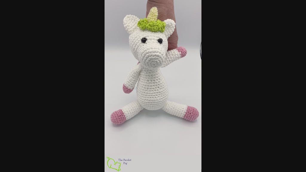 Lily is my first unicorn amigurumi. She's made of sturdy cotton yarn in white, pink, teal and green. She has a cute little yellow horn with three green flowers surrounding her head. She's a soft, squishy toy but still pretty indestructible and meant to last a life-time.  Video shown.