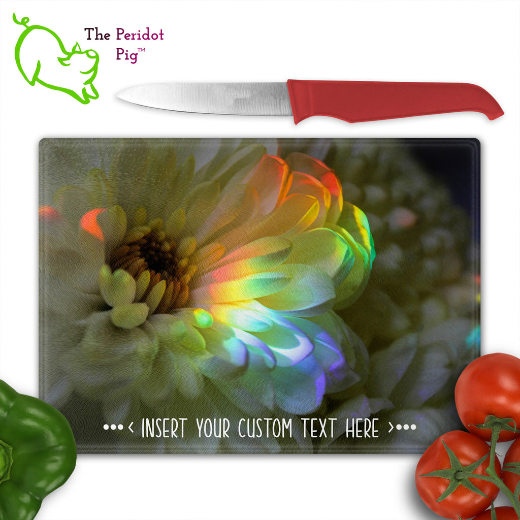 These beautiful tempered glass cutting boards are a wonderful keepsake!  They can be personalized with names, quotes or dates. This one features a large white chrysanthemum with a refracted rainbow splashed across it in a vivid and detailed print. Front view with cutlery.
