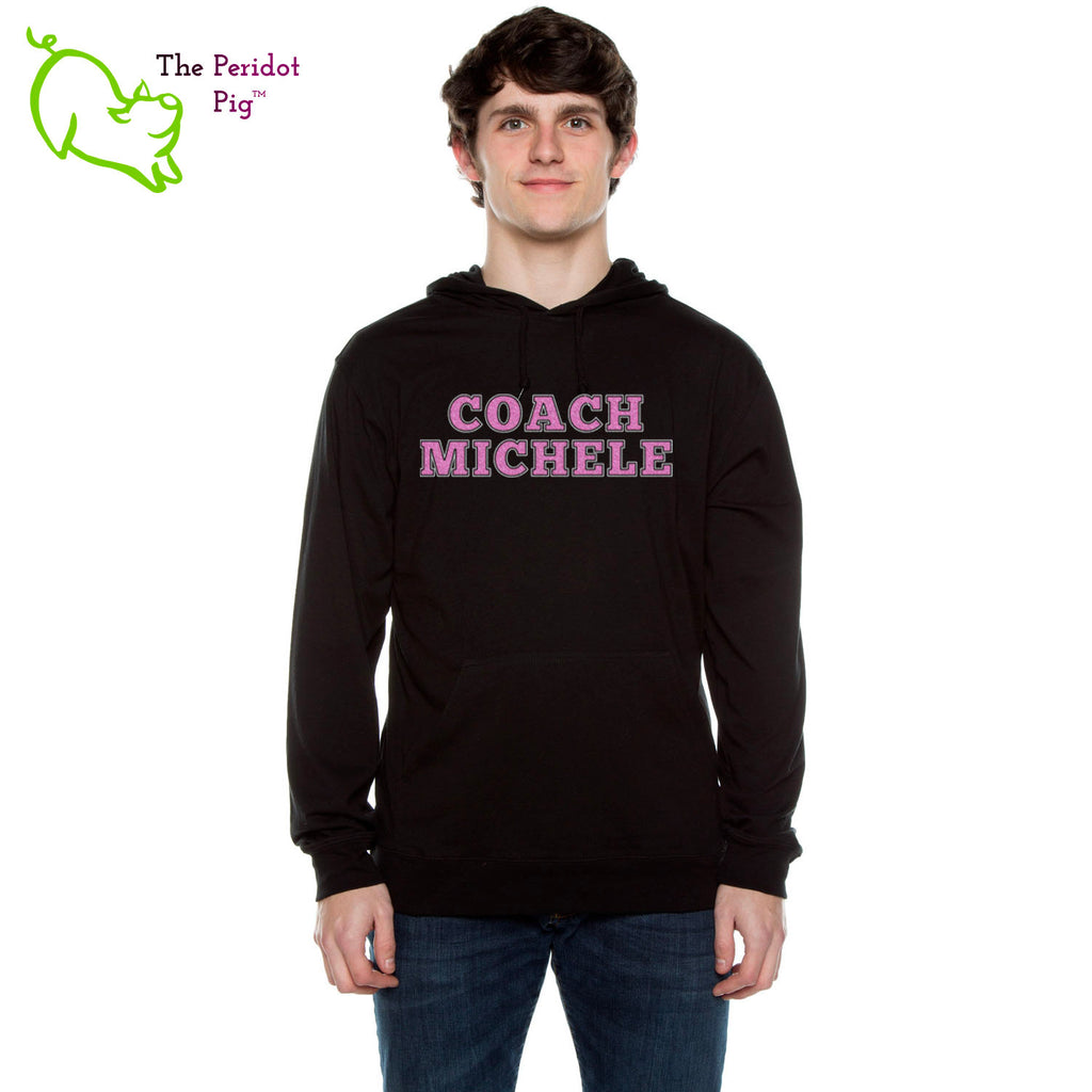 The Coach Michele long sleeve t-shirt hoodie is a light-weight version of your classic pullover hoodie. The front features the text, "Coach Michele" in two colors of glitter vinyl. The back is blank. Front view shown in Black.