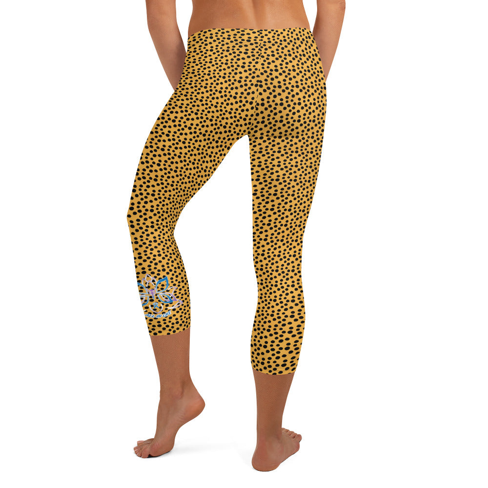 Kristin Zako embodies the "Wild & Free" spirit of her print capri leggings. These are printed in vivid color with a stylized cheetah print.  The words, "WILD & FREE" are down the right leg and you'll find Kristin's logo on the lower left leg. Cheetah style -Back view.