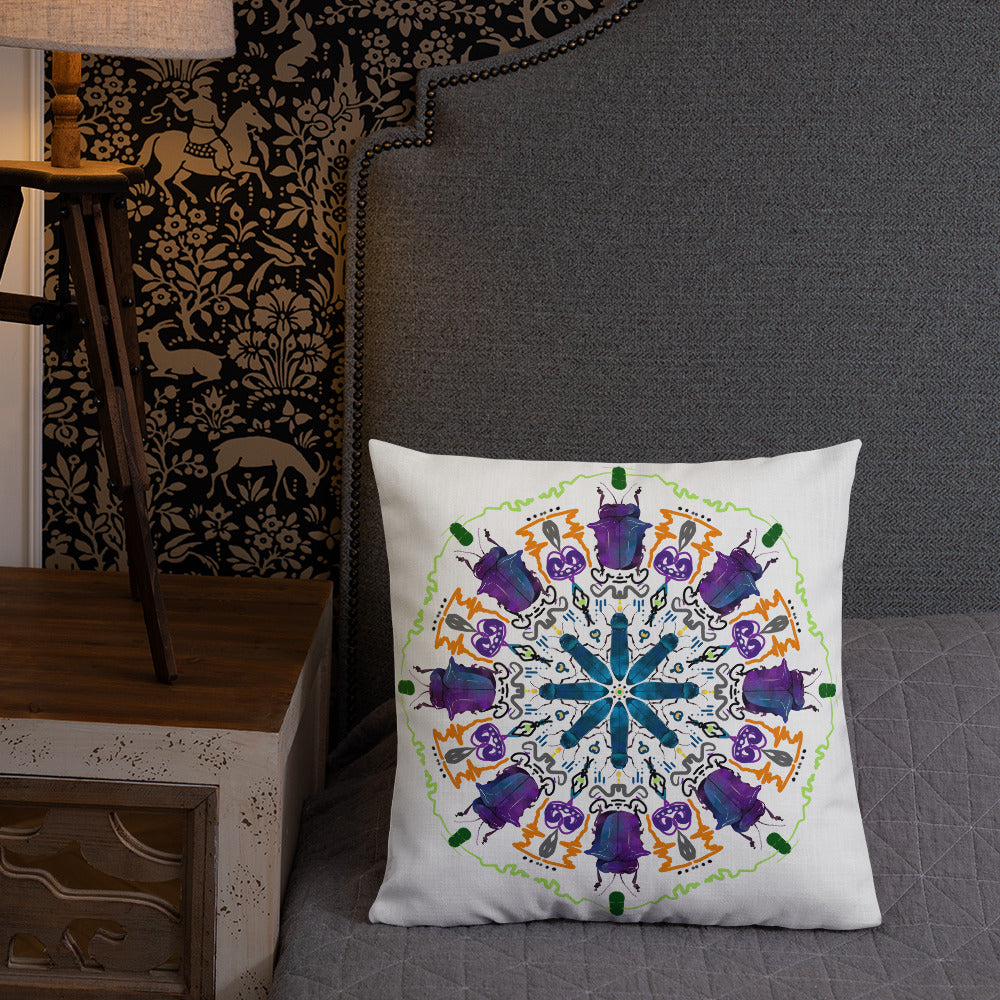 A colorful mandala of beetles graces this white pillow and is availble in either 18"x18" or 22"x22" sizes. The image is printed on both the front and back. The larger beetle has shades of violet and blue. Shown in size 18x18 on a bed.