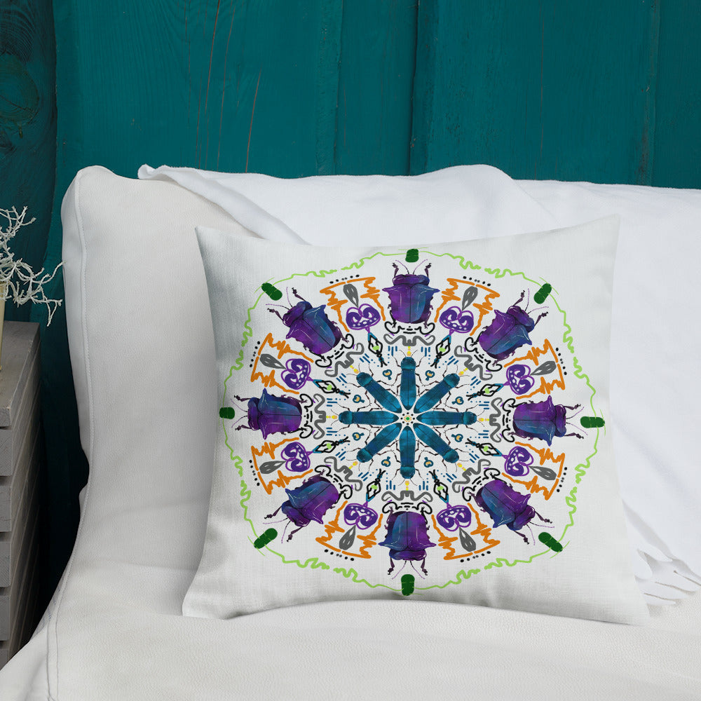 A colorful mandala of beetles graces this white pillow and is availble in either 18"x18" or 22"x22" sizes. The image is printed on both the front and back. The larger beetle has shades of violet and blue. Shown in size 18x18 on a bed.