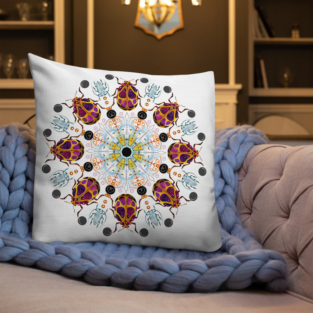 A colorful mandala of beetles graces this white pillow. The larger beetle has shades of violet surrounded by gold. The smaller beetle is in a delicate shade of blue. Printed on a bright, white casing these bugs really pop! Shown in size 22"x22" on a couch sitting on a throw blankeet.