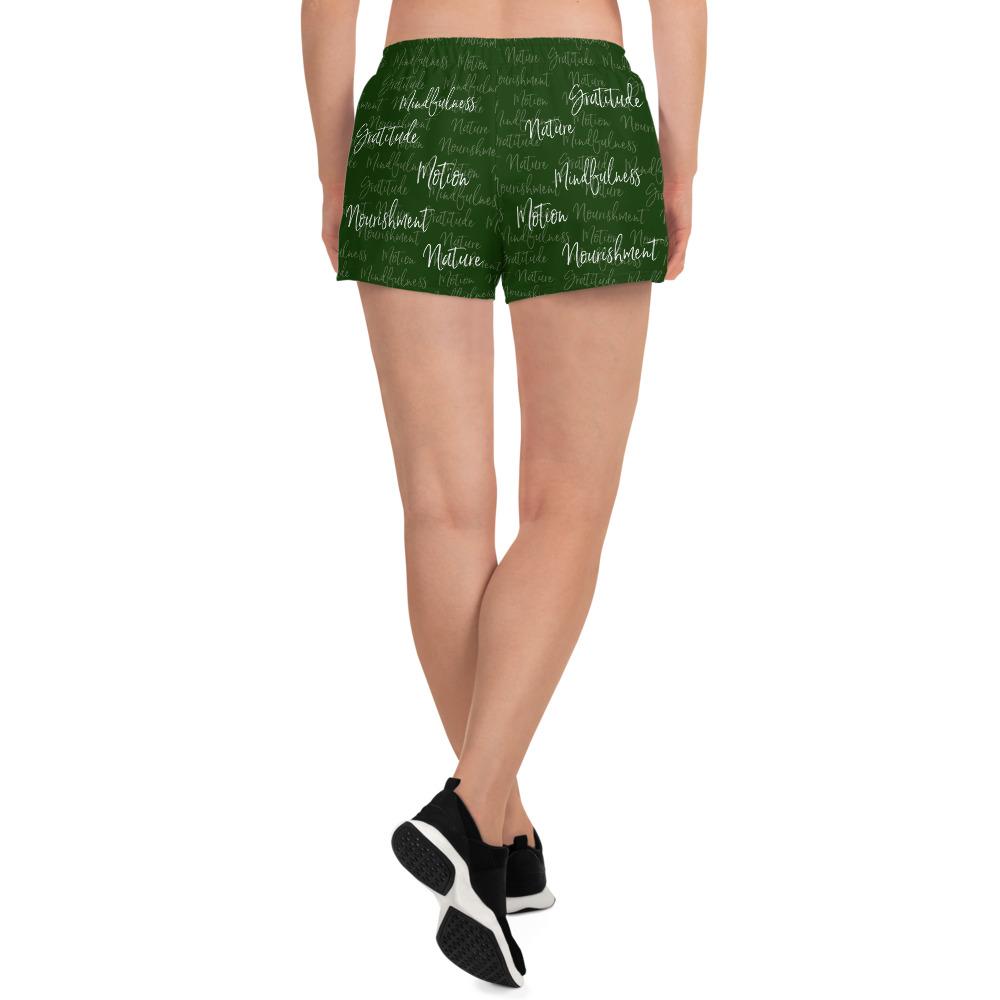 These athletic women's short shorts are so comfy and made from such a versatile fabric that you won't feel out of place at any sports event. The Kristin Zako print is filled with her four pillars phrases and topped off with her logo on the front right leg. Shown in green. Back view.