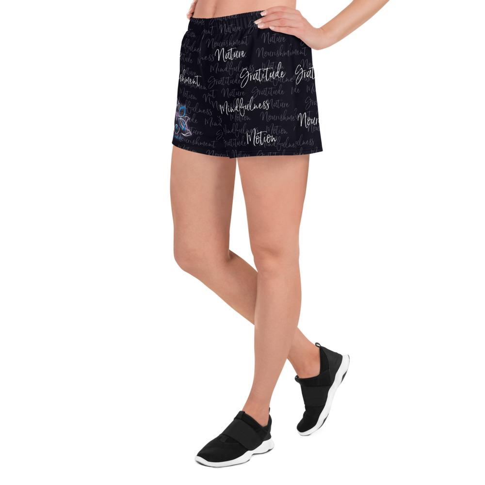These athletic women's short shorts are so comfy and made from such a versatile fabric that you won't feel out of place at any sports event. The Kristin Zako print is filled with her four pillars phrases and topped off with her logo on the front right leg. Shown in black. Left view.