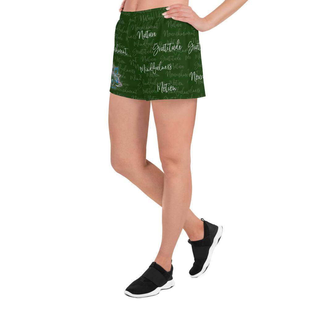 These athletic women's short shorts are so comfy and made from such a versatile fabric that you won't feel out of place at any sports event. The Kristin Zako print is filled with her four pillars phrases and topped off with her logo on the front right leg. Shown in green. Left view.