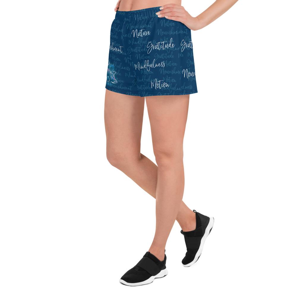 These athletic women's short shorts are so comfy and made from such a versatile fabric that you won't feel out of place at any sports event. The Kristin Zako print is filled with her four pillars phrases and topped off with her logo on the front right leg. Shown in blue. Left view.