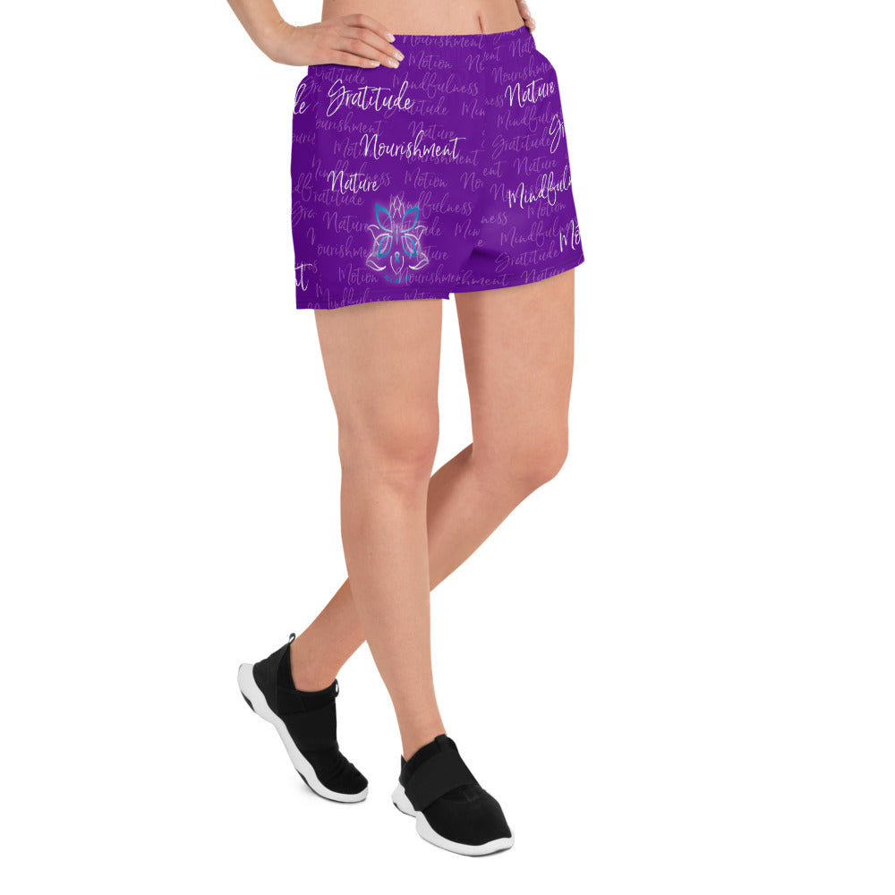 These athletic women's short shorts are so comfy and made from such a versatile fabric that you won't feel out of place at any sports event. The Kristin Zako print is filled with her four pillars phrases and topped off with her logo on the front right leg. Shown in purple. Right view.