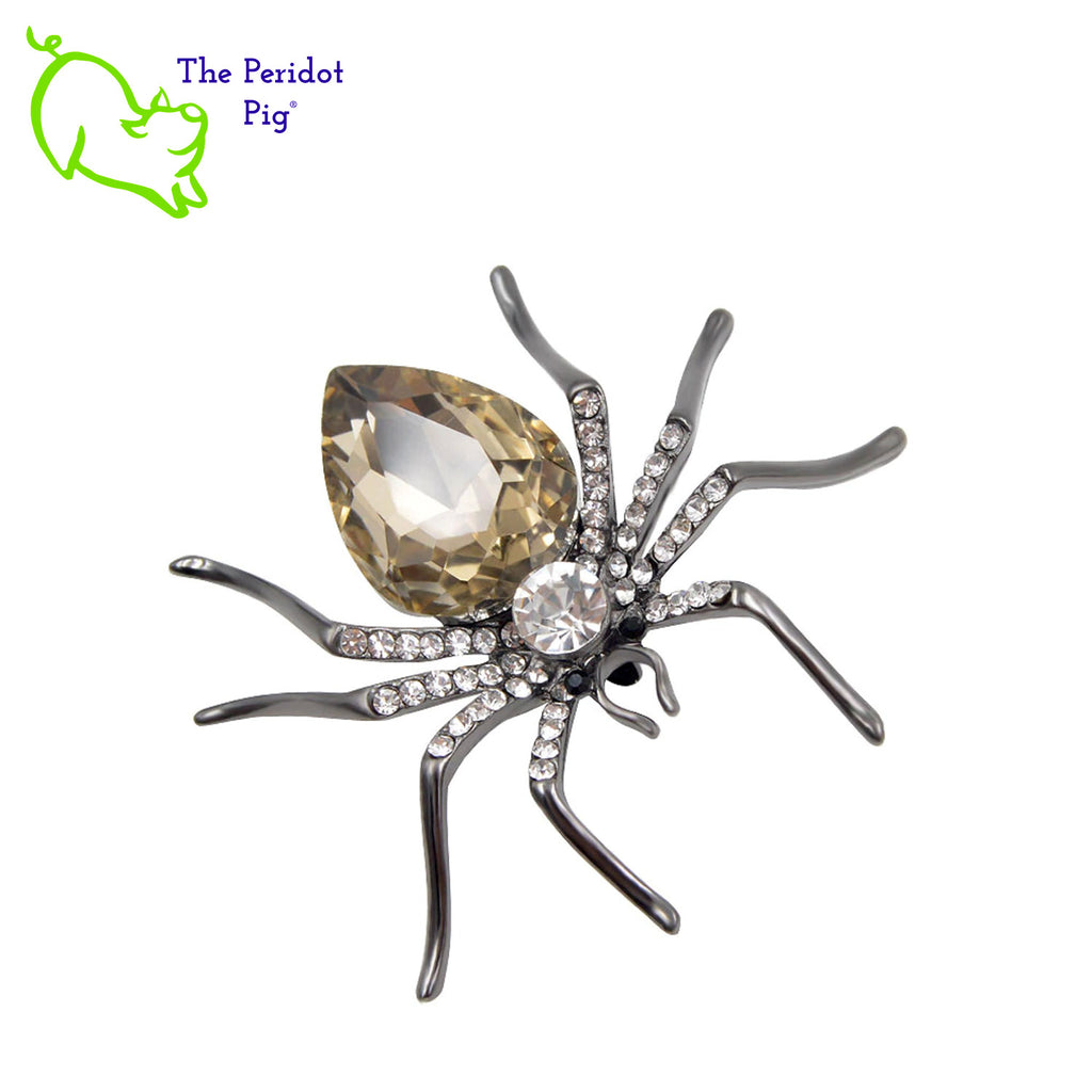 A simple and stylized spider brooch available in 3 different color options. A perfect addition to a scarf or hat. Front view in champagne.